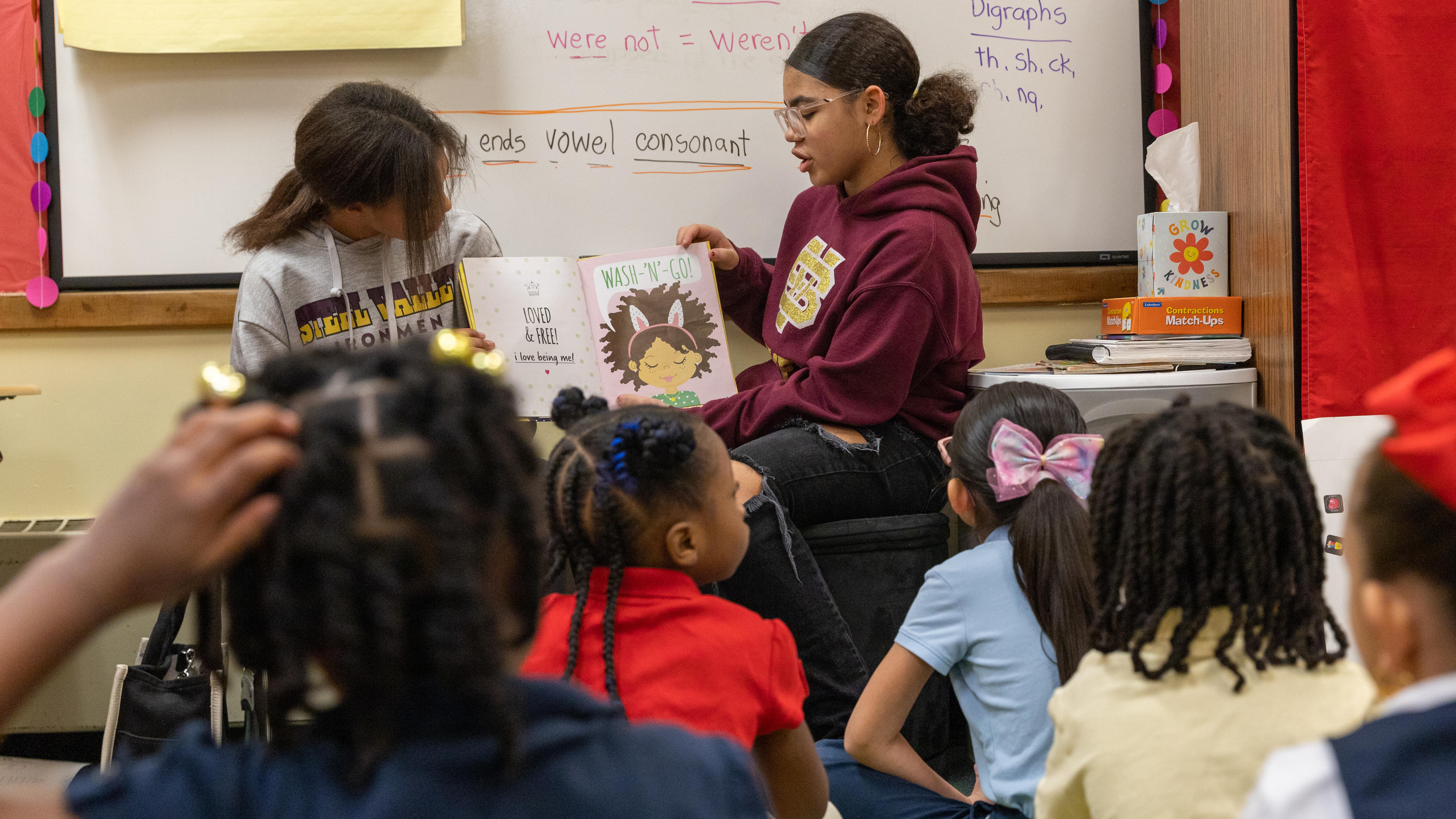 Middle school students read to a group of elementary students