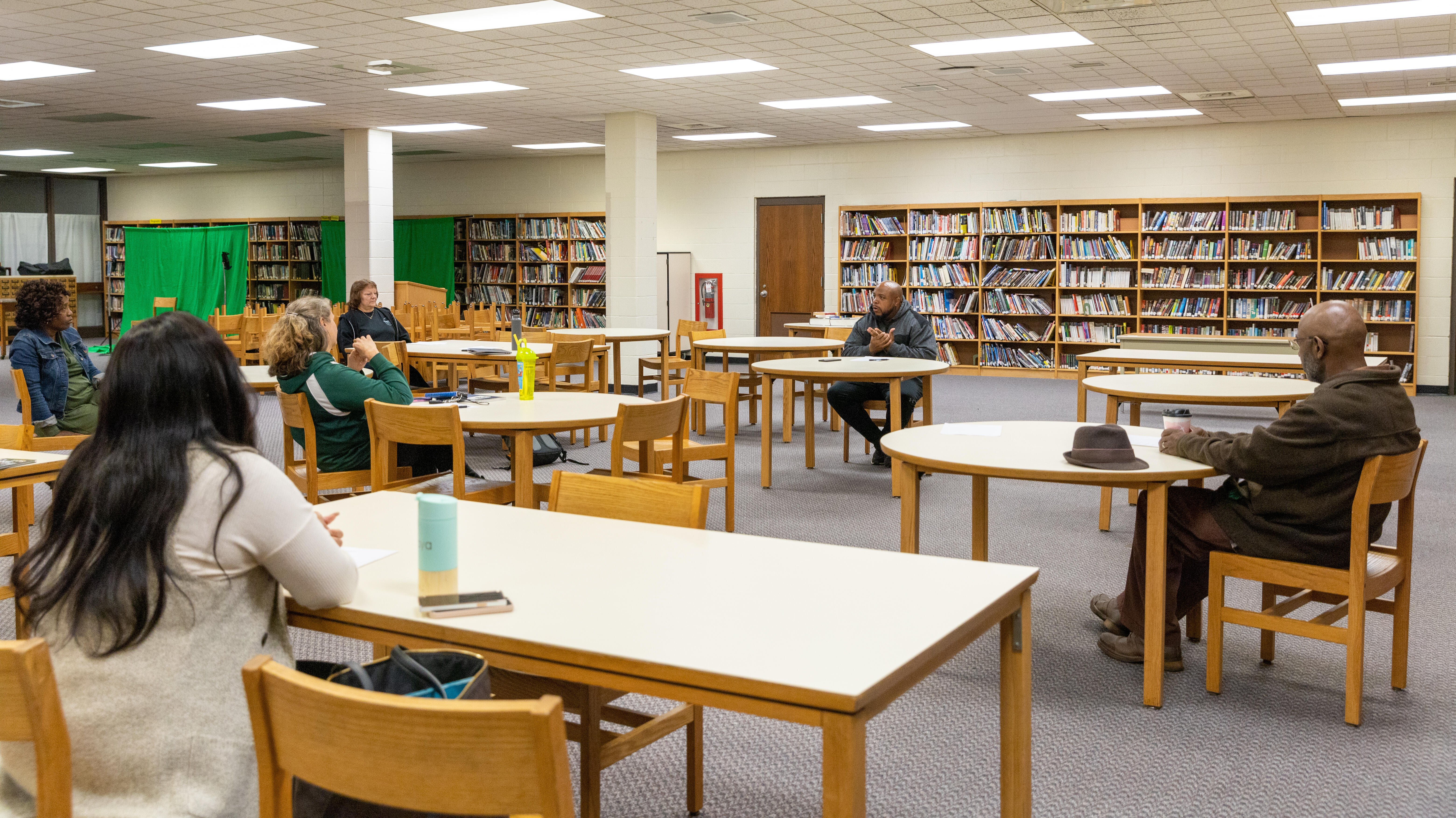 Members of the A-TSI committee meeting sit and talk during a recent gathering in the high school library.