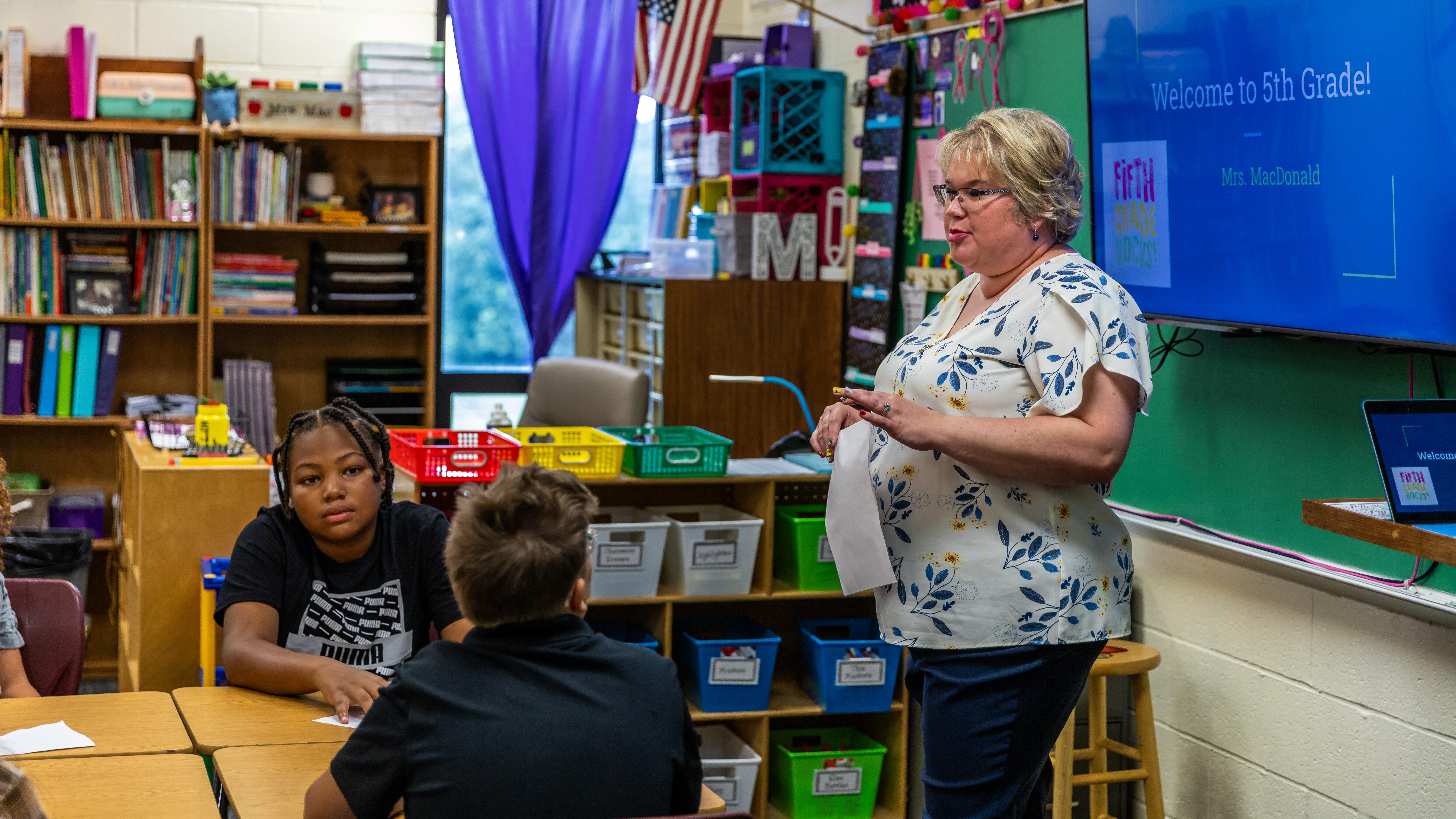 A teacher talks to middle school students in a classroom