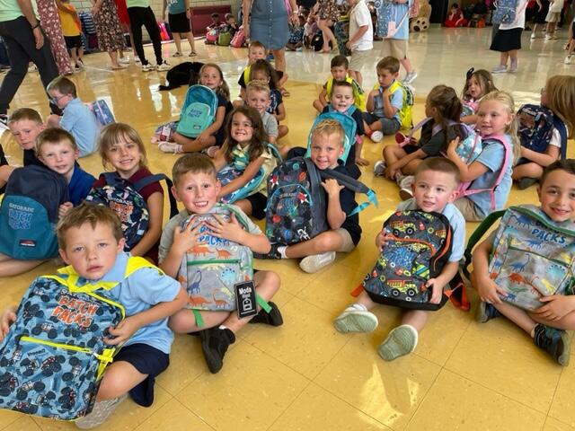 Park students show off their new back packs in the gym