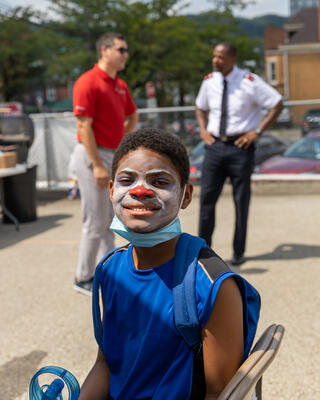 A young boy smiles as he shows off the clown nose and face paint he received at the Salvation Army Steel Valley Corps' Back to School Backpack Bash
