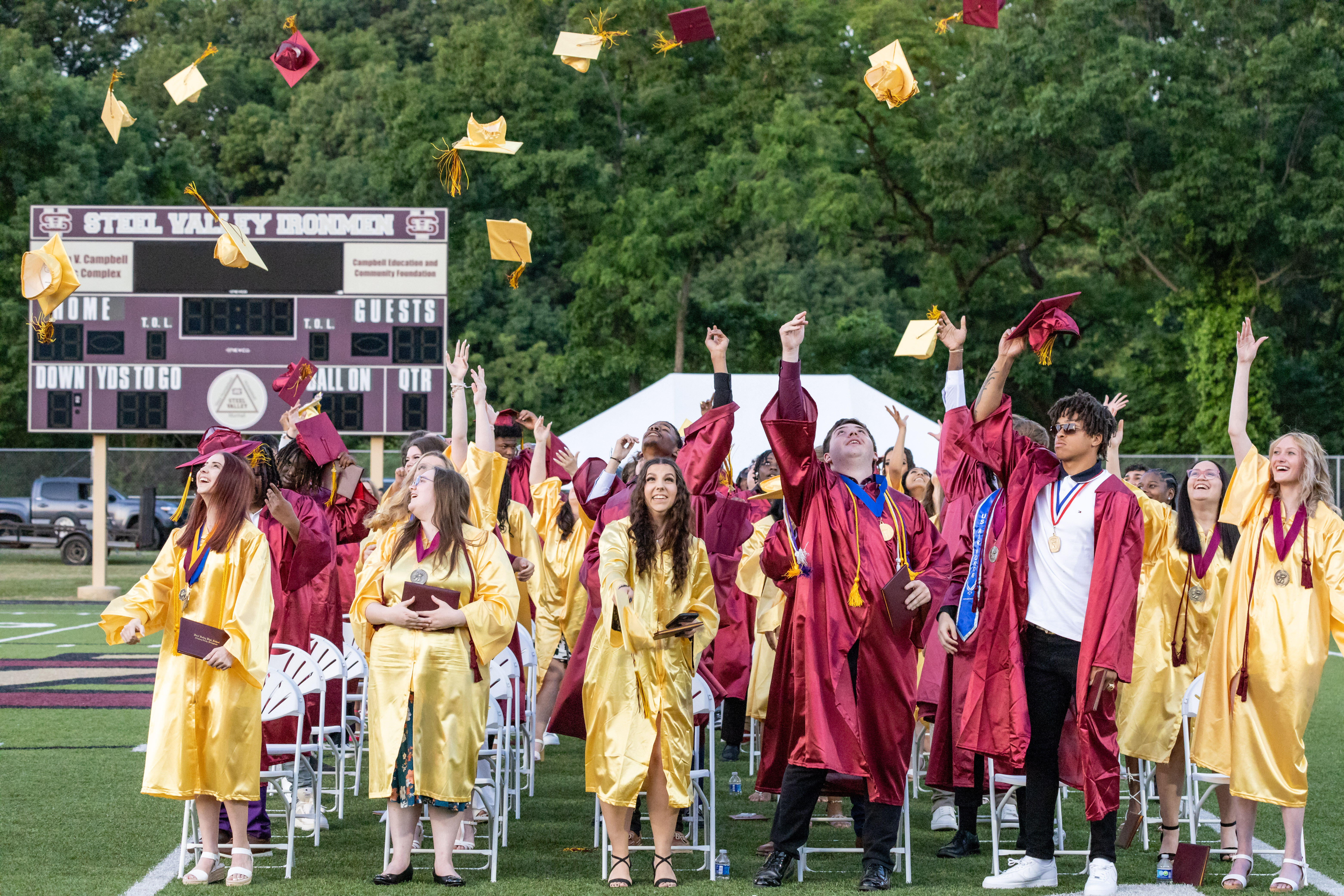 Graduates toss caps in the air.
