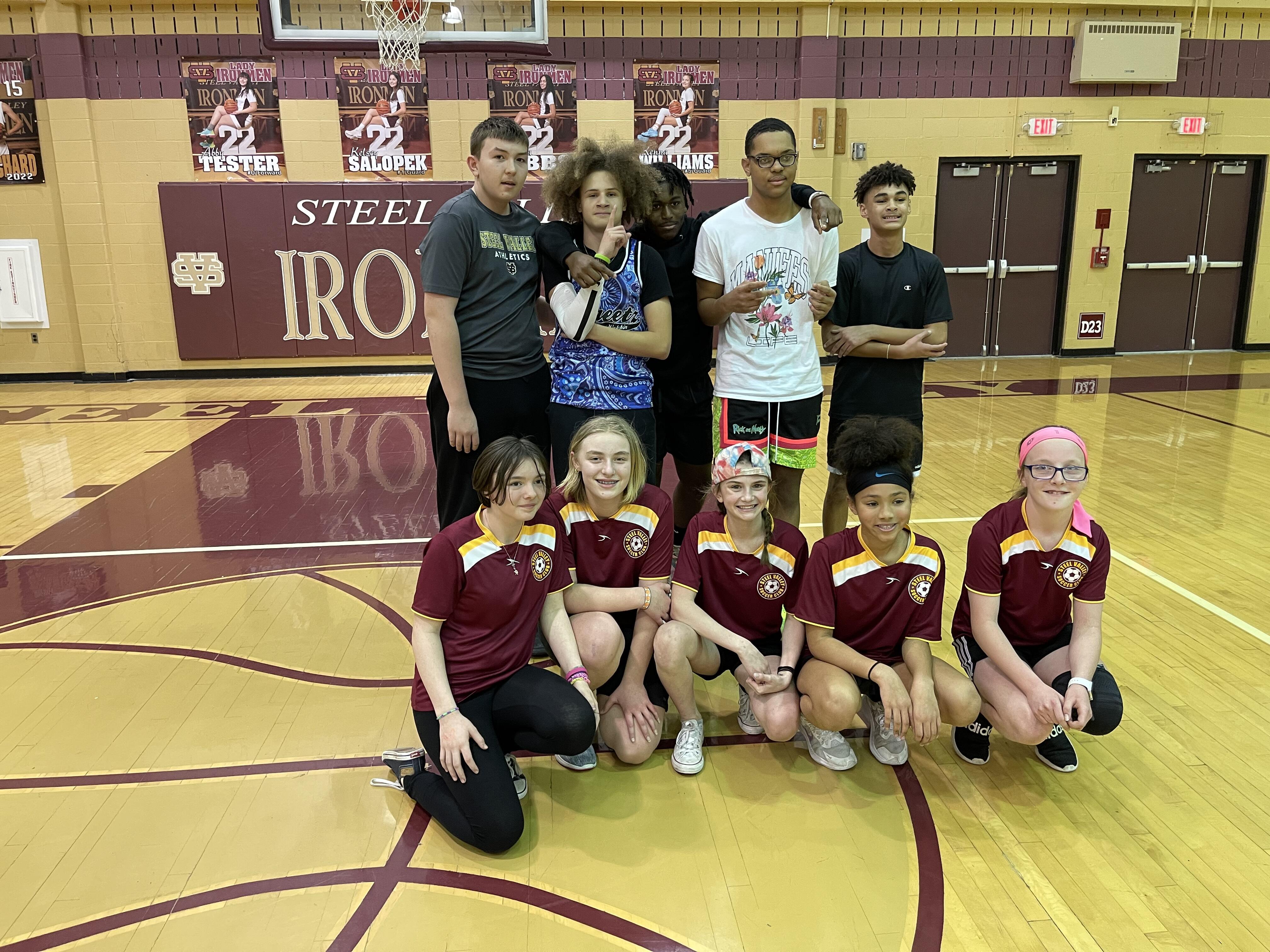 Two middle school dodgeball teams pose for pictures after winning the March Madness Dodgeball Tournament