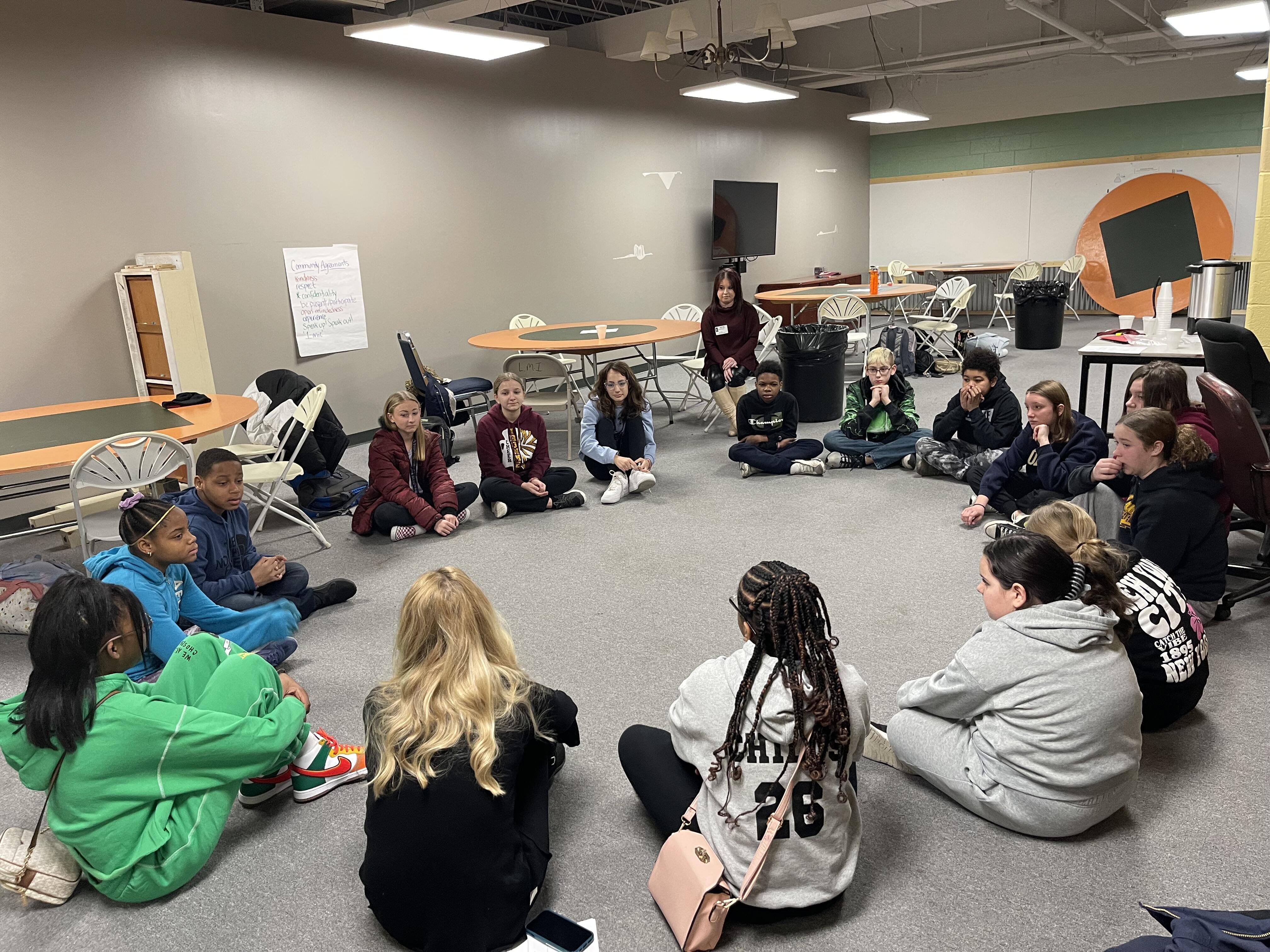 Students sit in a circle as part of a mental health workshop