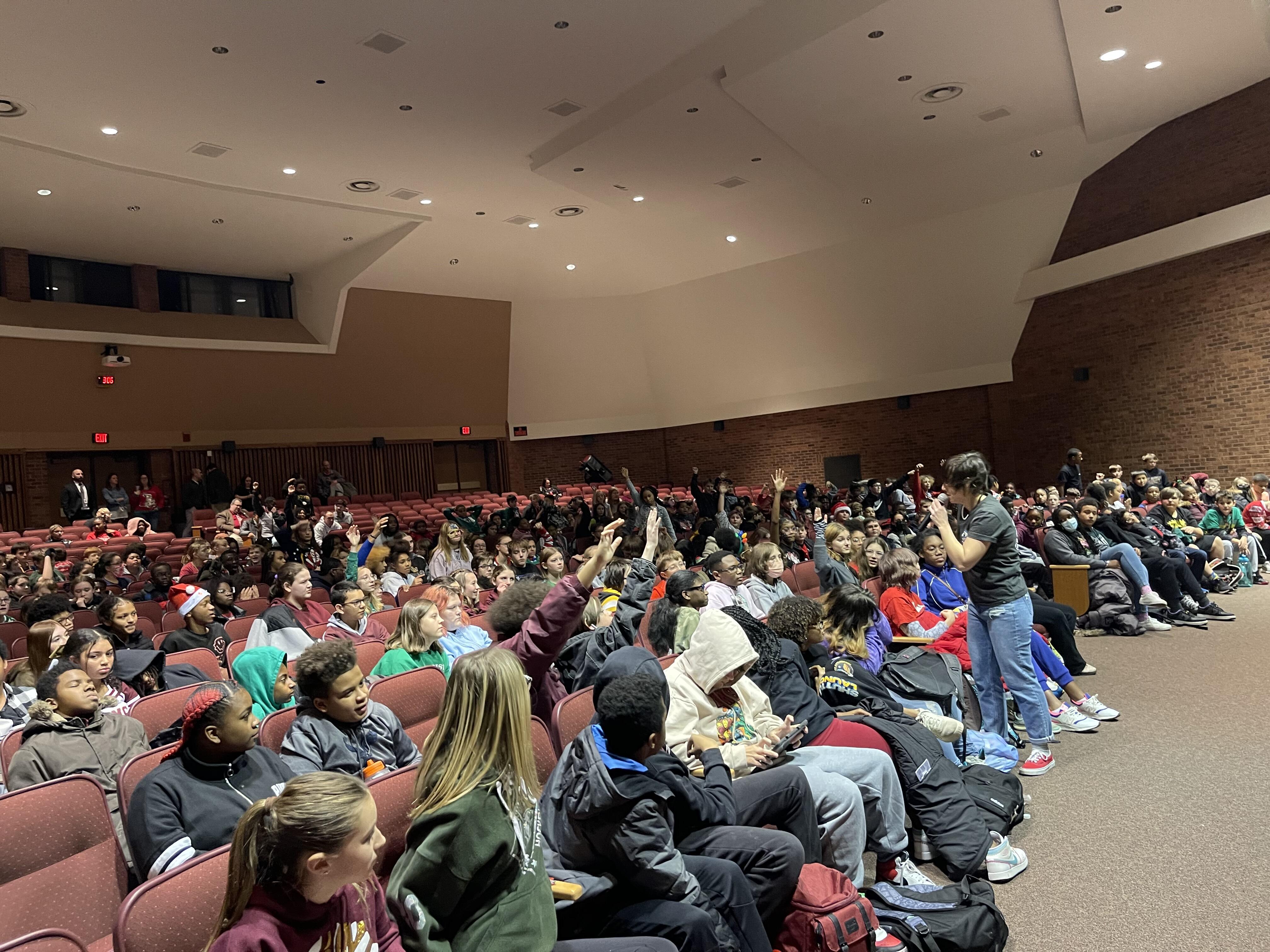Middle school students seated in an auditorium watch a performance of Josh & Gab, a musical duo with a positive message.