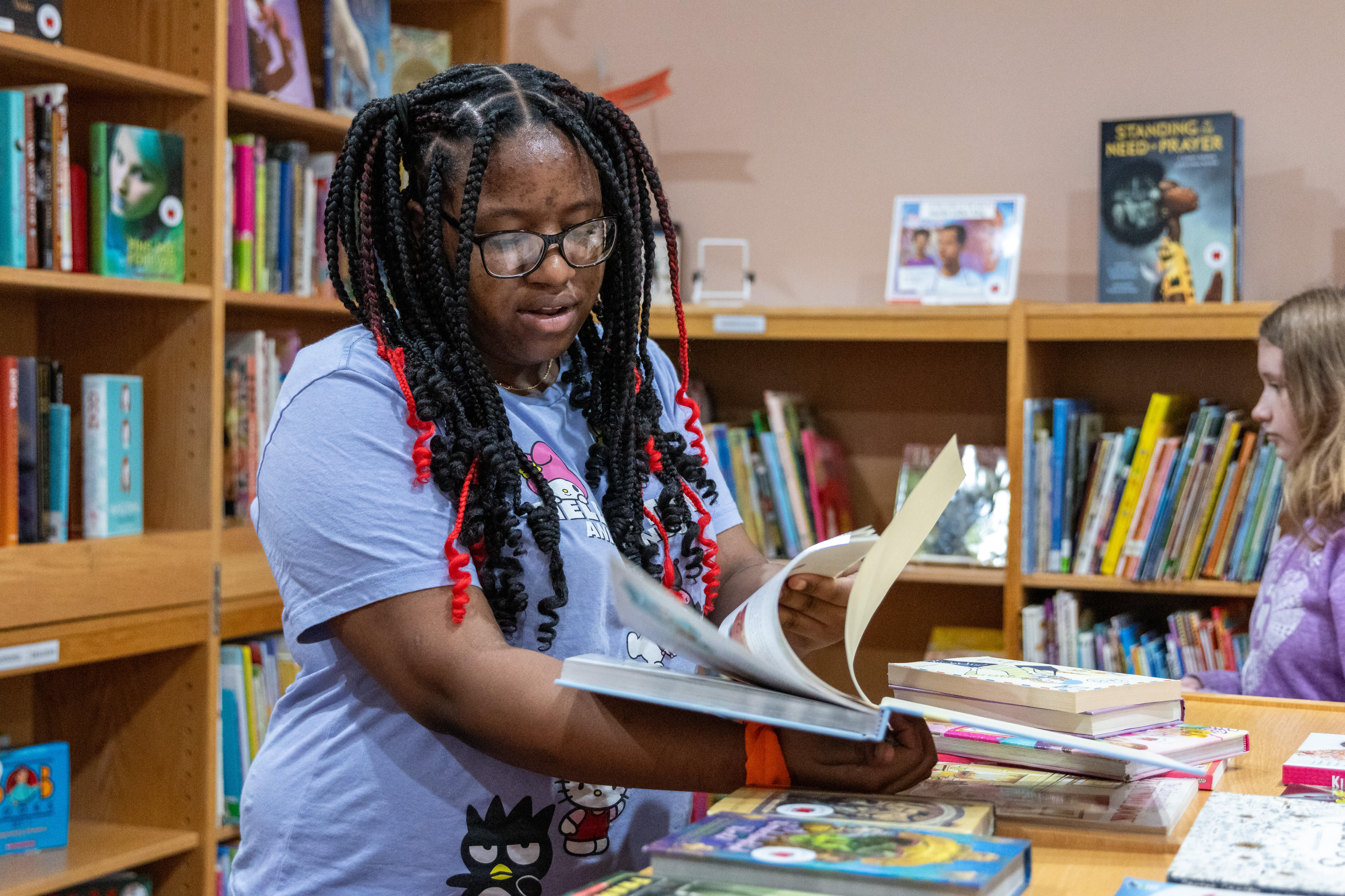 A sixth grader explores donated books at Reading Ready Pittsburgh