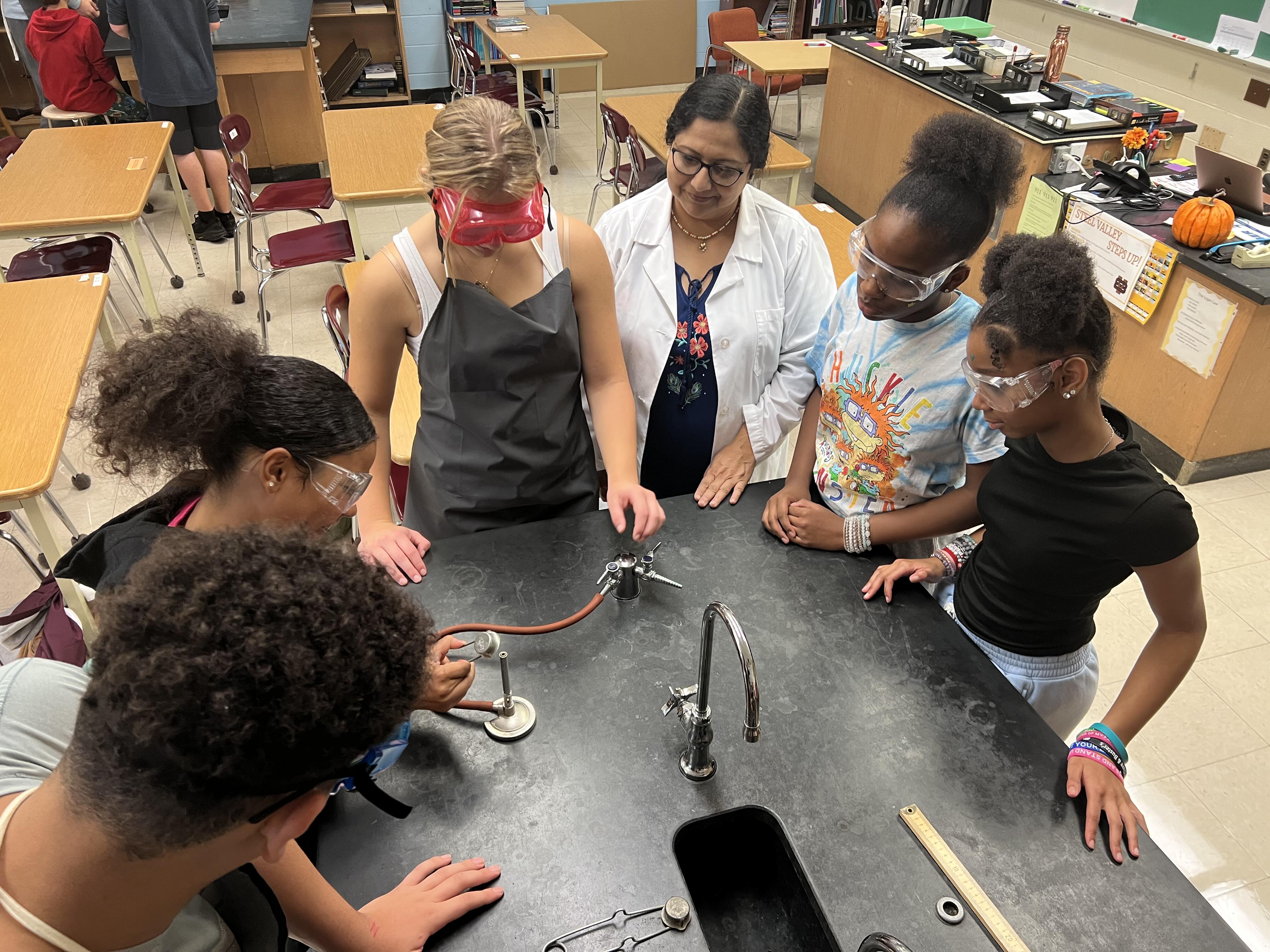 Middle school and high school students collaborate on science experiments in a classroom lab