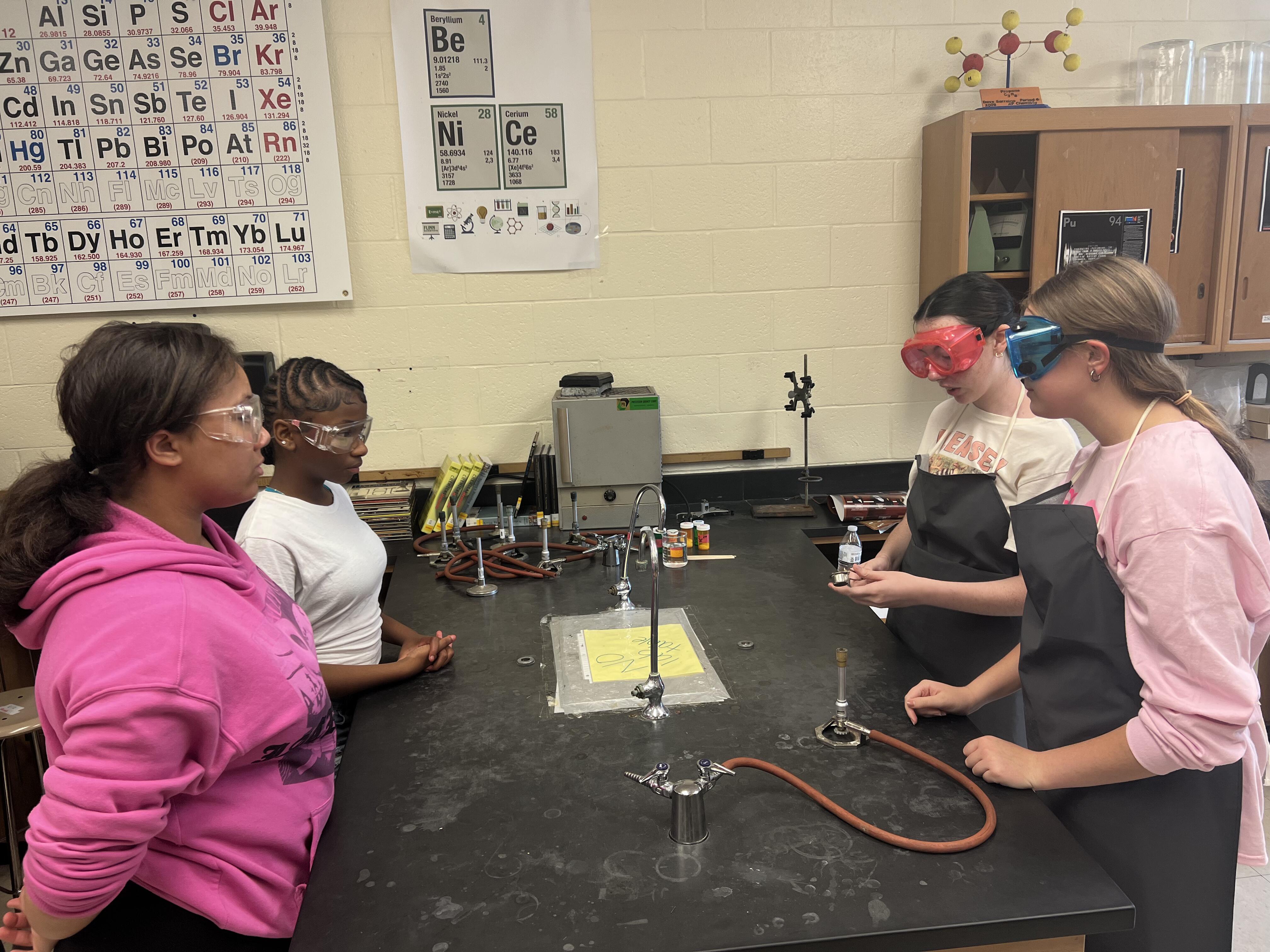 Middle school and high school students collaborate on science experiments in a classroom lab