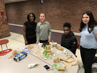 Female students pose next to gingerbread creation