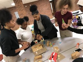 In action, students add pieces to gingerbread house