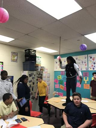 Student holds measuring stick against the ceiling