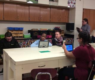 Students working on tablets at desk