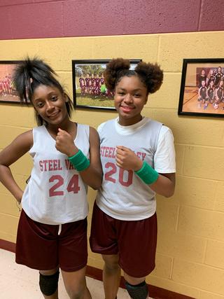 Two female students in basketball uniforms