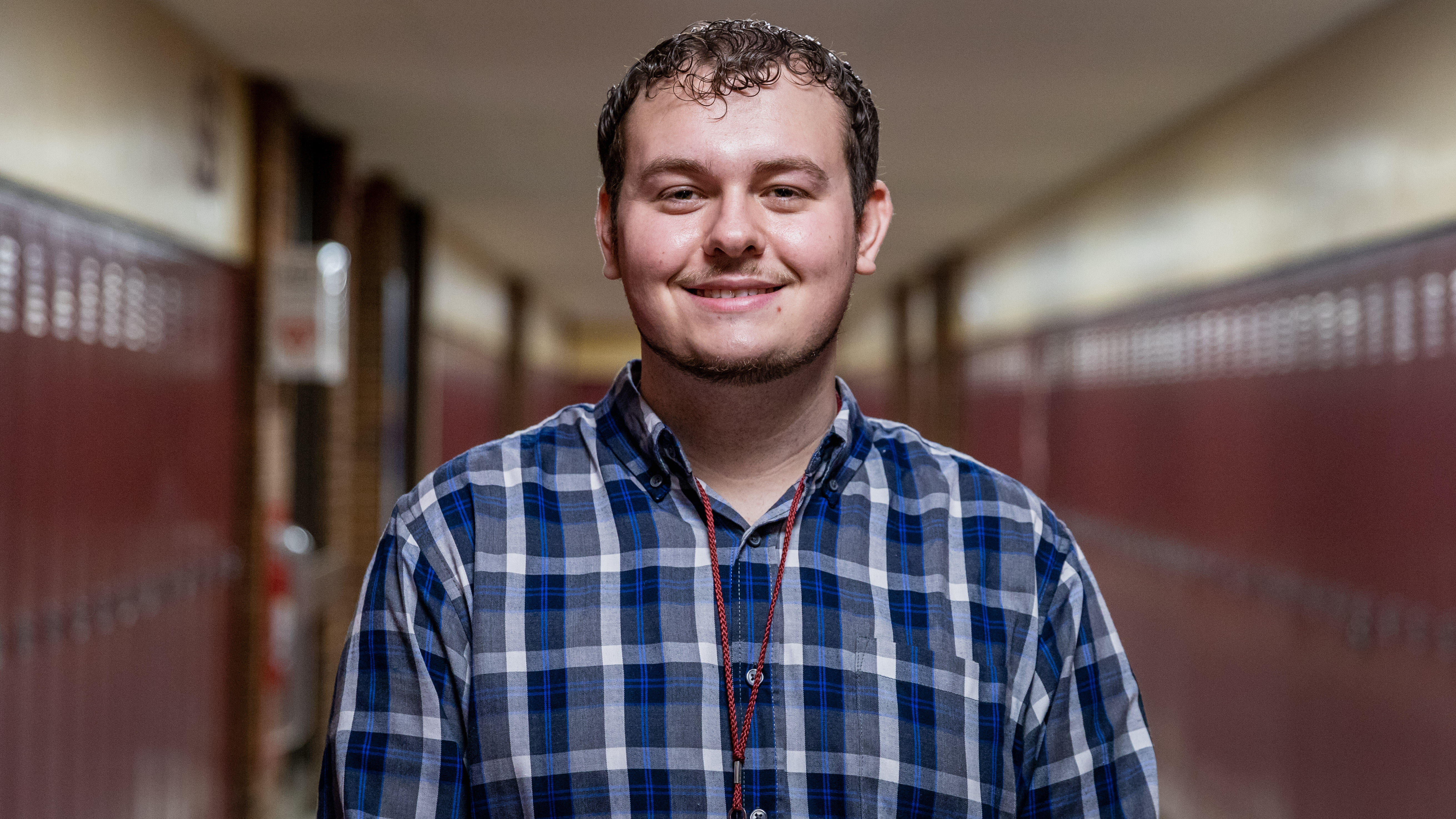 Special education teacher Austin Riley poses in the high school hallway