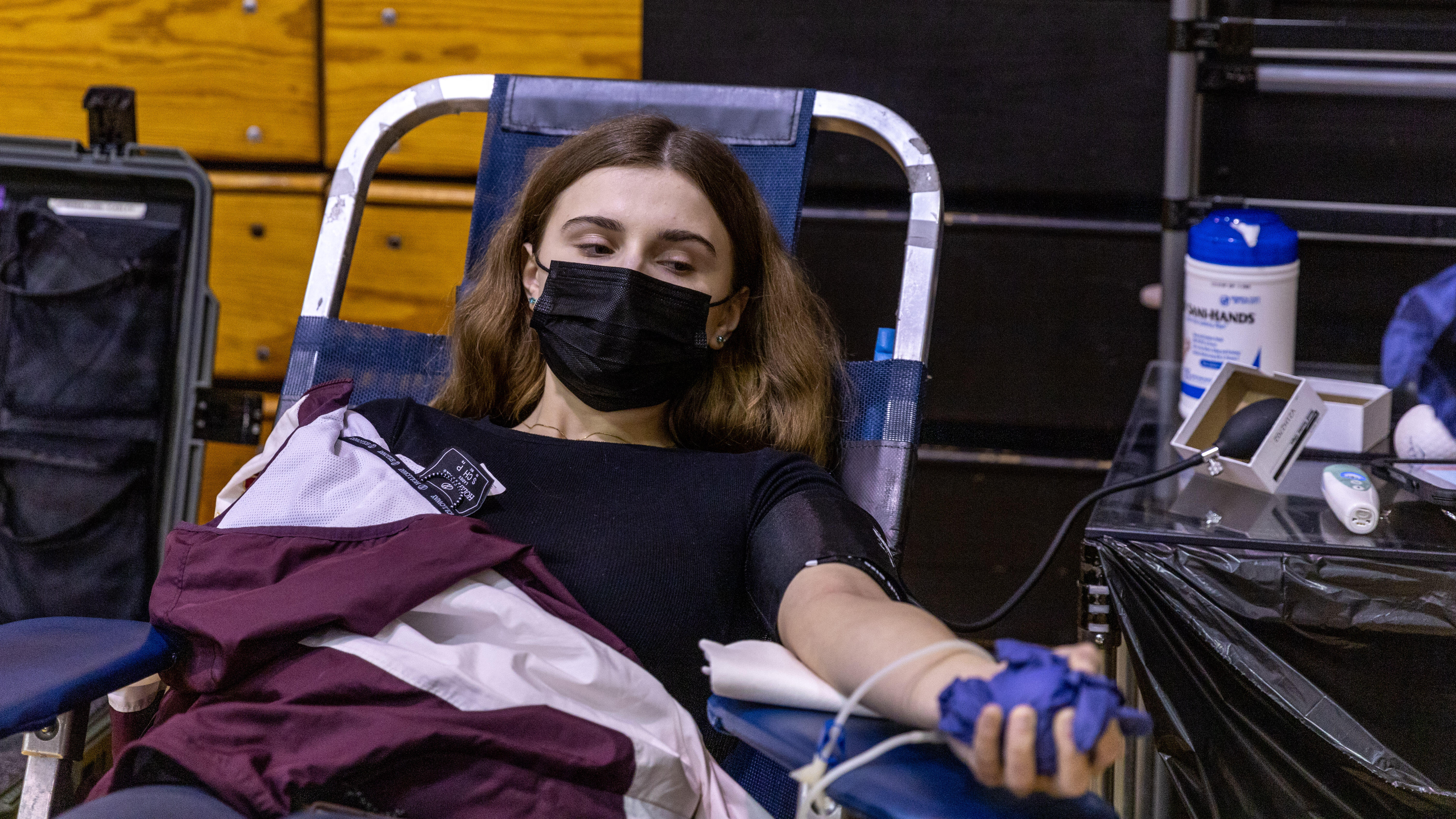 A teen donates blood as part of a blood drive at Steel Valley High School