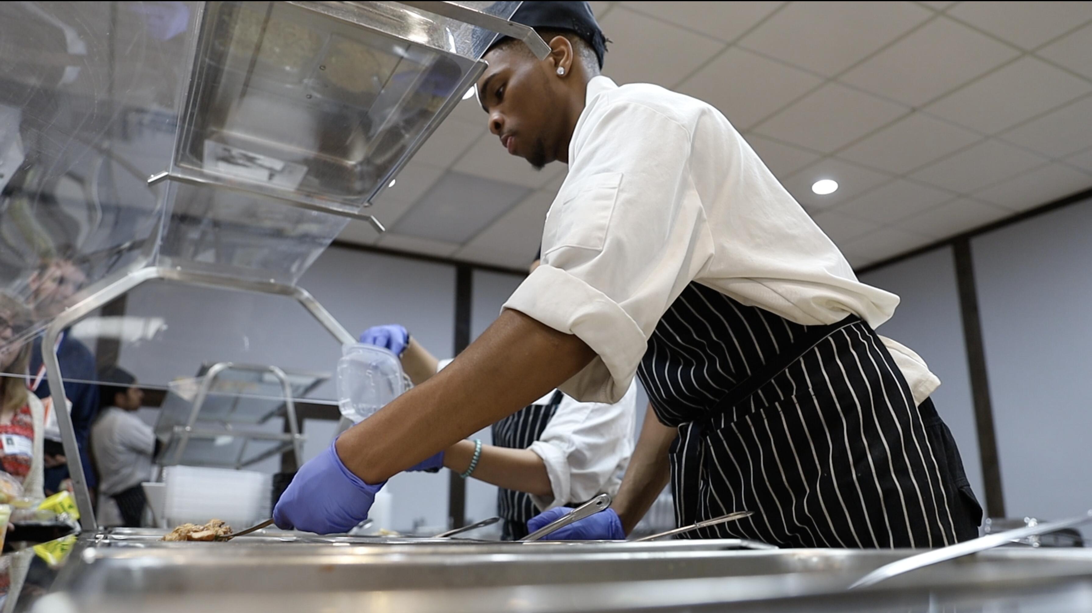 A career and technical education student serves freshly made food
